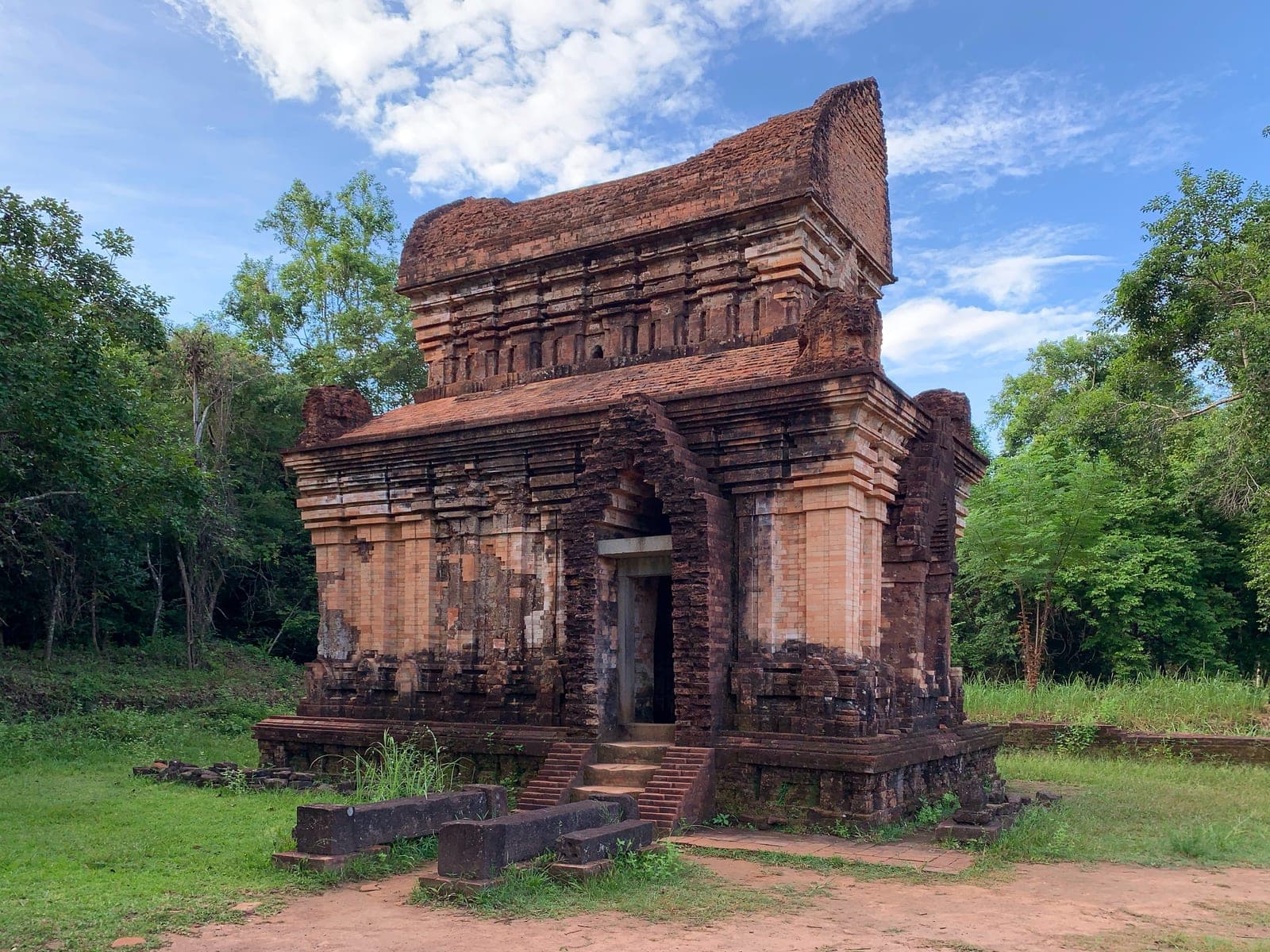 Weathered brick temple tower at Mỹ Sơn Sanctuary in Vietnam's central highlands, showing intricate Cham architectural craftsmanship and surviving war-era damage.