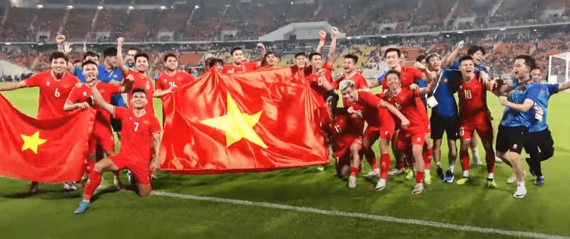 Vietnamese football players celebrate with the national flag after winning the 2024 ASEAN Championship title.