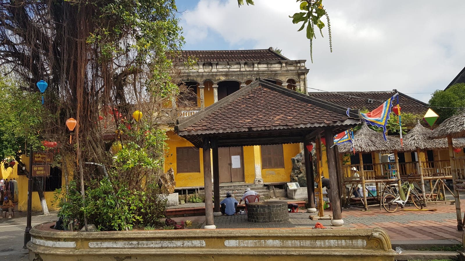 Historic Hoi An ancient town with traditional buildings, illuminated lanterns, and riverside architecture at sunset