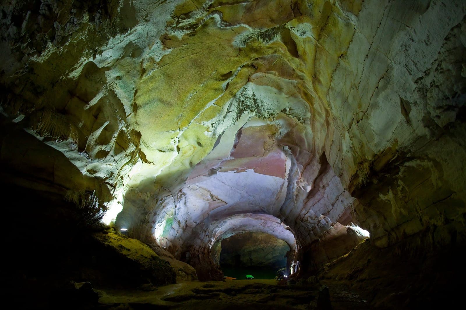 Limestone cave chamber with ancient stone formations and natural light filtering through the cavern interior