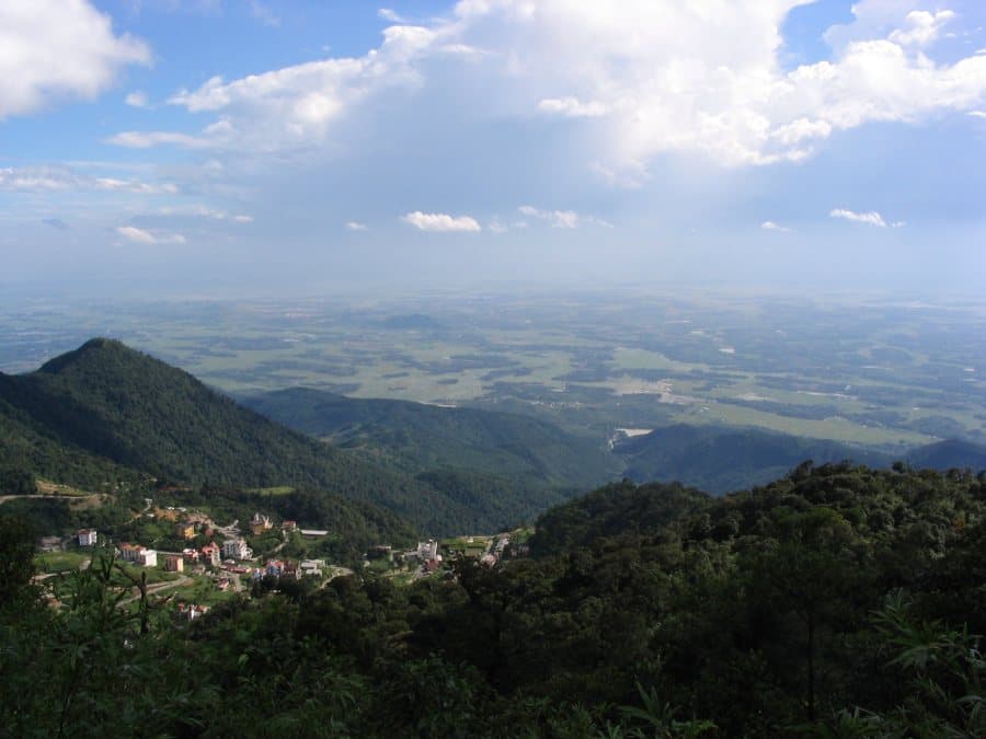 Scenic mountain landscape with forested slopes and peaks shrouded in mist and clouds at high elevation